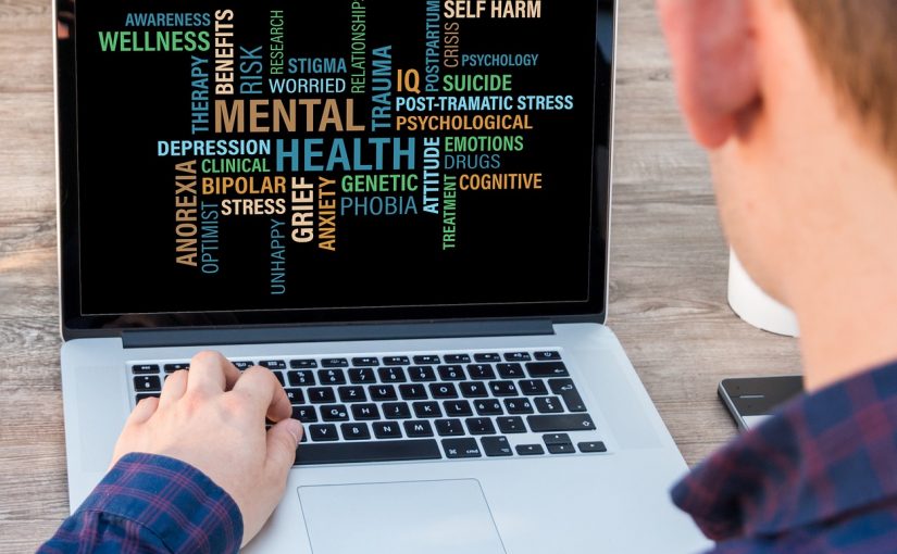Mann sitzt am Computer, auf dem Bildschirm Namen verschiedener psychischer Erkrankungen
